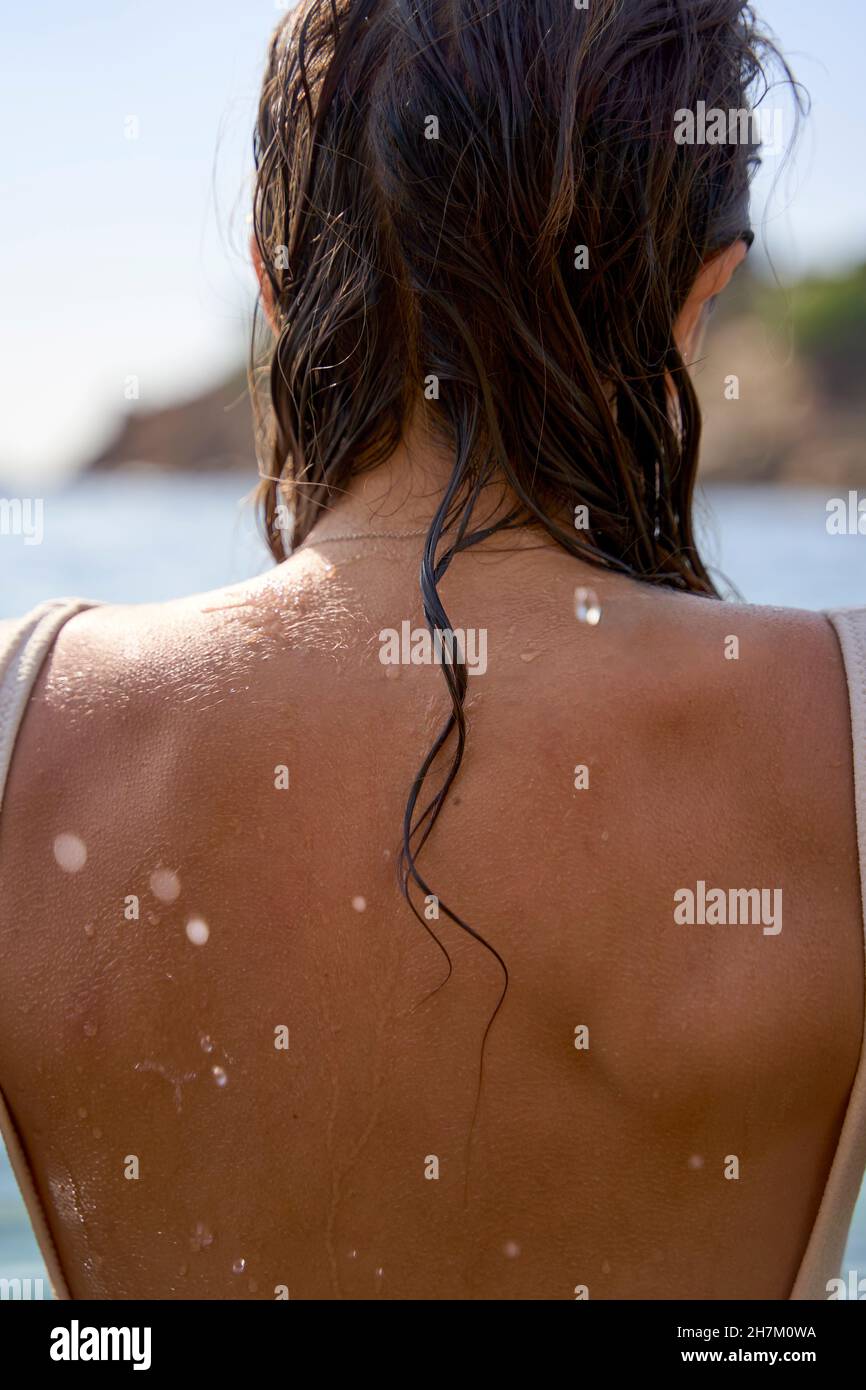 Junge Frau mit nassem Haar und zurück am Strand Stockfoto