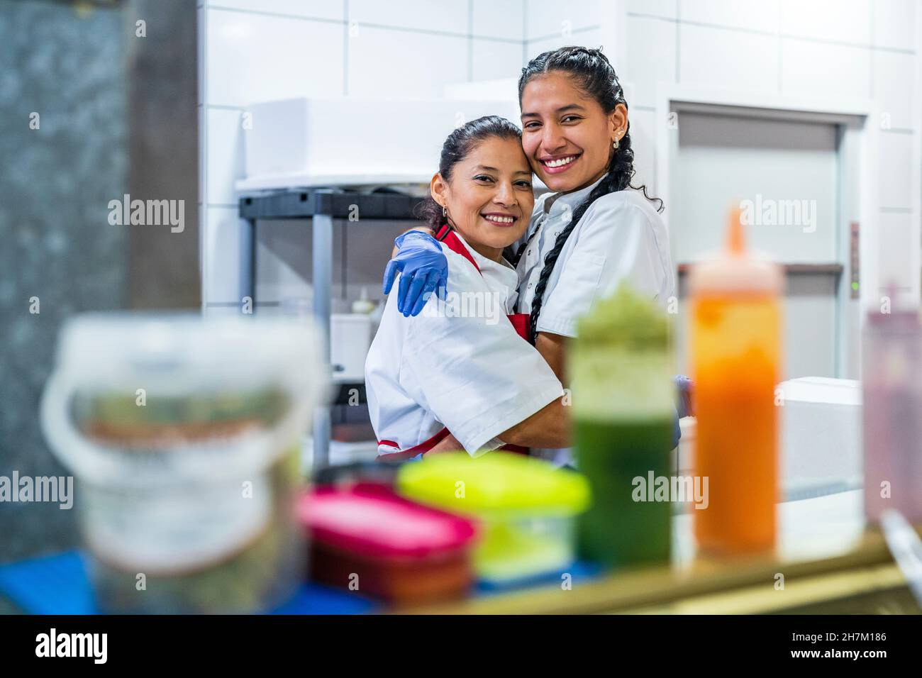 Küchenhelfer in Chefköchin weiß umarmen sich im Restaurant Stockfoto