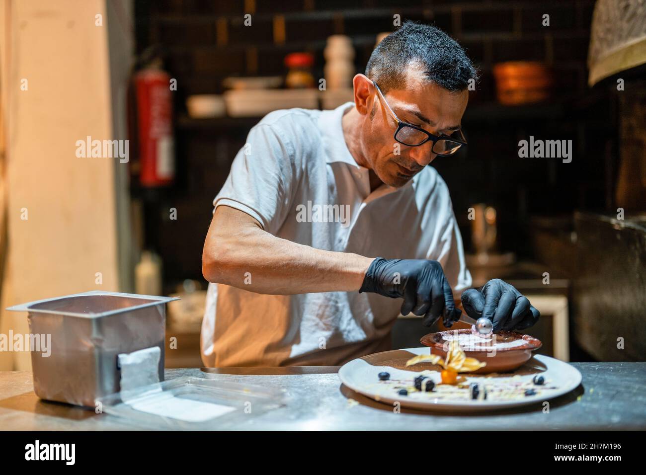 Konzentrierter Koch, der Dessert in der Küche dekoriert Stockfoto