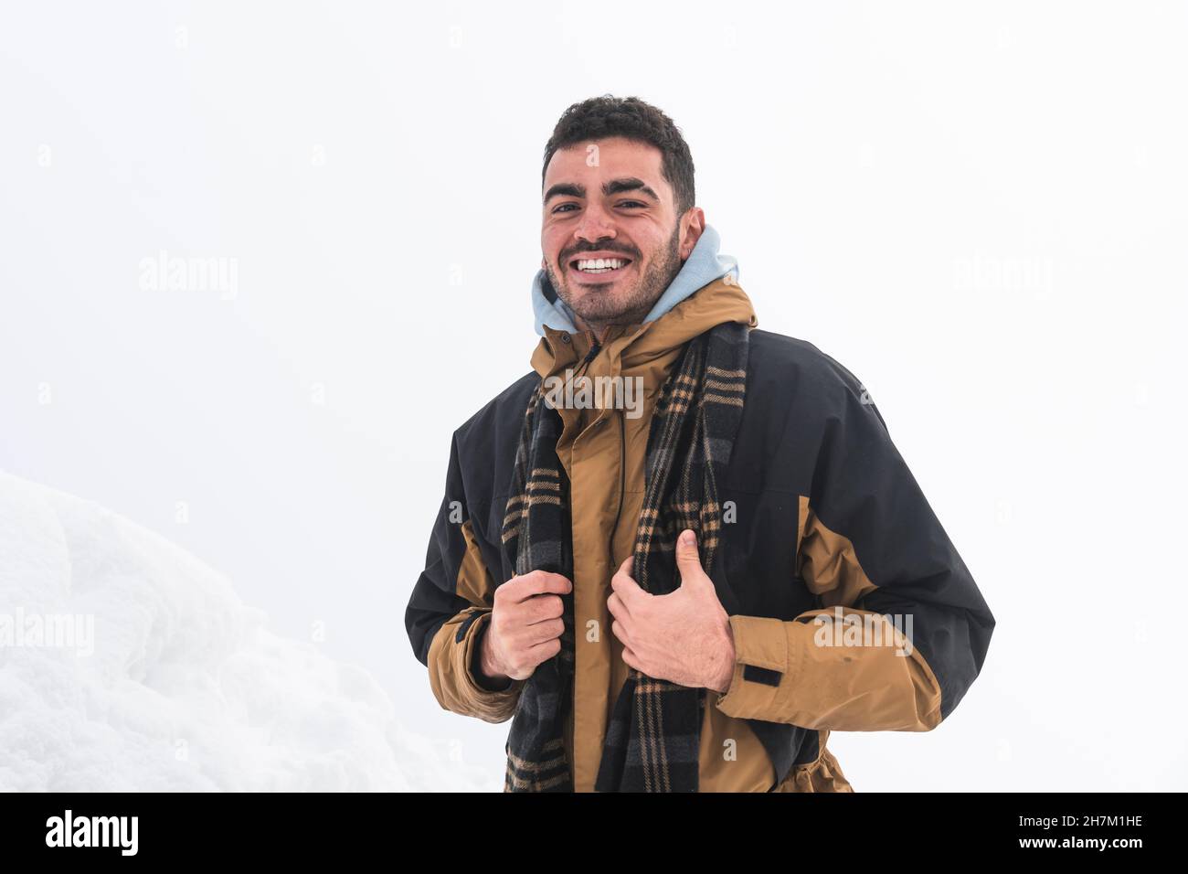 Lächelnder Mann, der Selfie durch die Kamera vor dem schneebedeckten Berg in Chamonix, Frankreich, macht Stockfoto