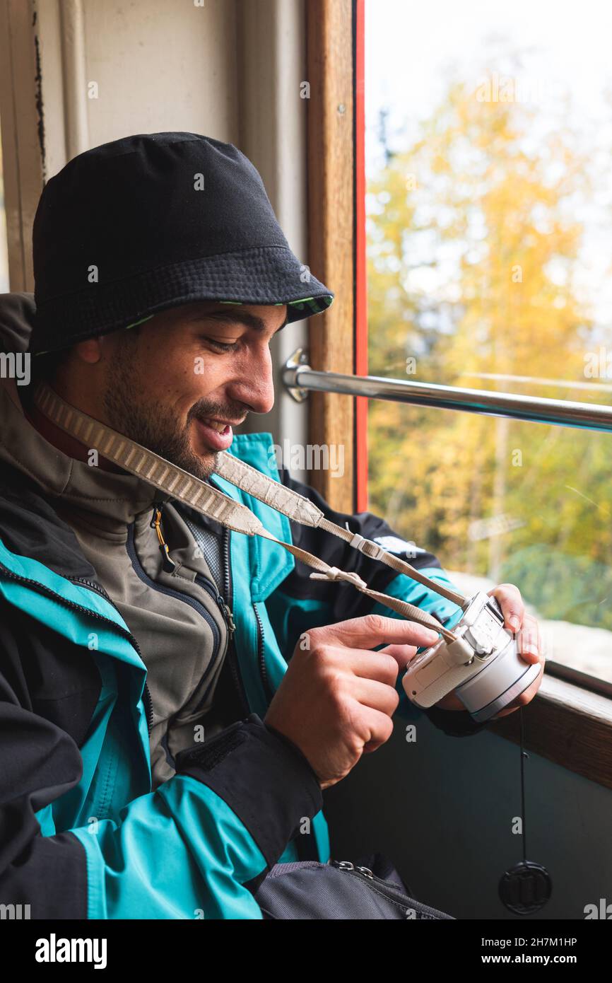Lächelnder Mann mit Hut im Urlaub im Zug Stockfoto