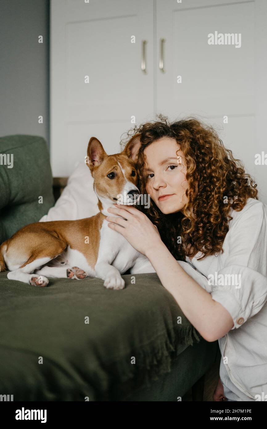 Frau umarmt Basenji Hund zu Hause Stockfoto