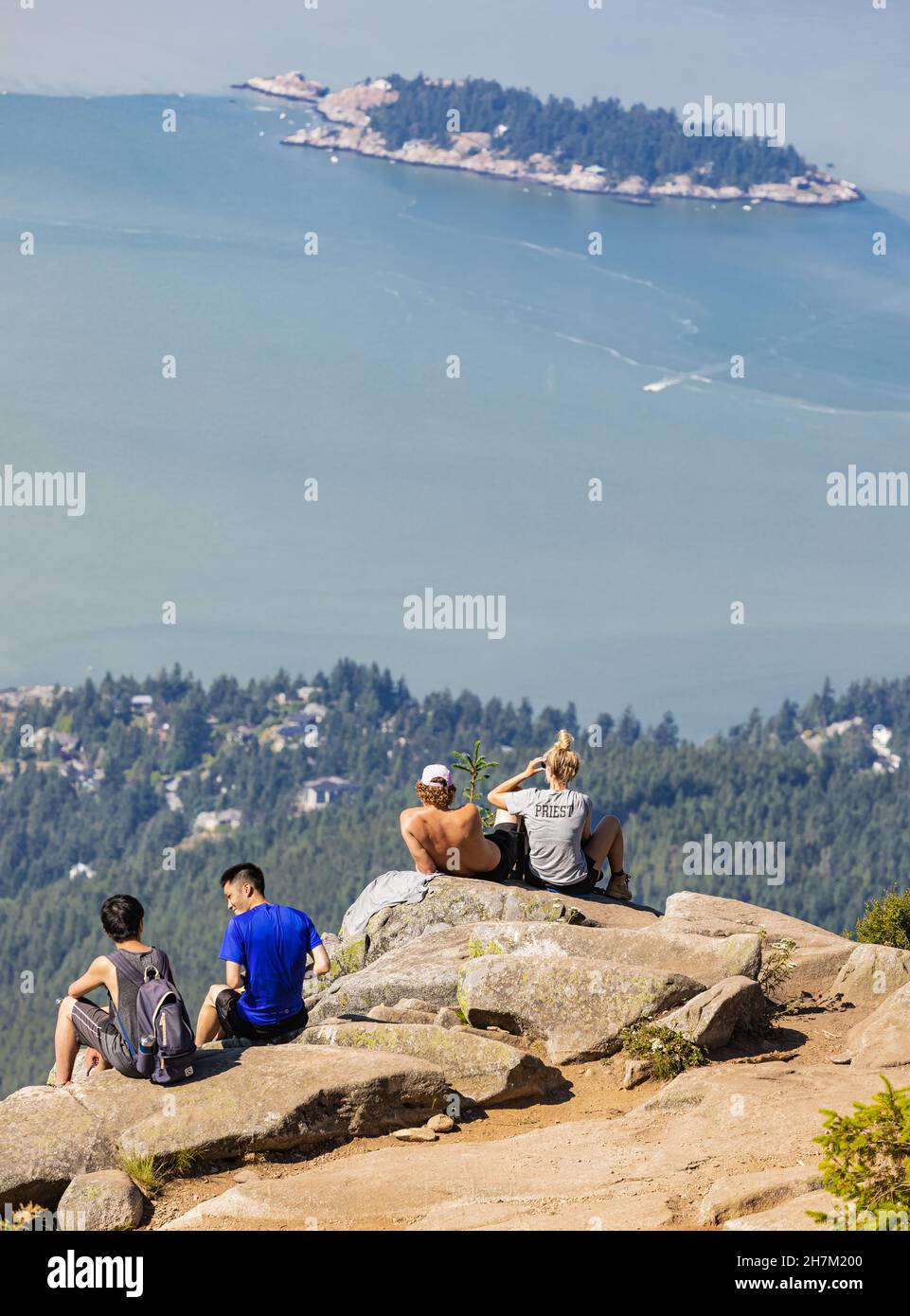 Eine Gruppe junger Wanderer sitzt auf einer Klippe und genießt die Aussicht von den Eagle Bluffs im Cypress Provincial Park, Kanada. Konzept Foto Wandern, Kopie Stockfoto