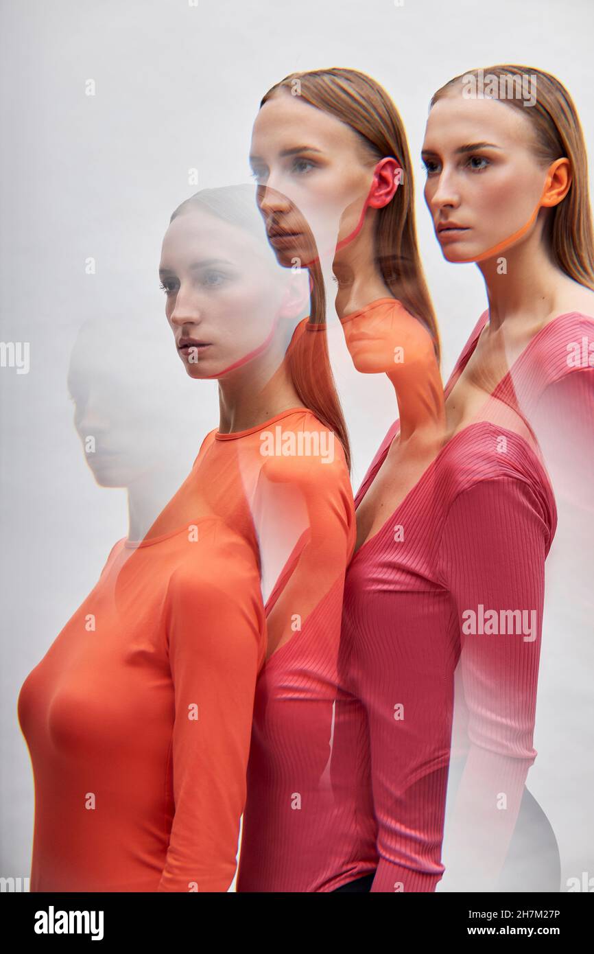 Mehrfachbelichtung von Zwillingsschwestern durch weißen Hintergrund Stockfoto