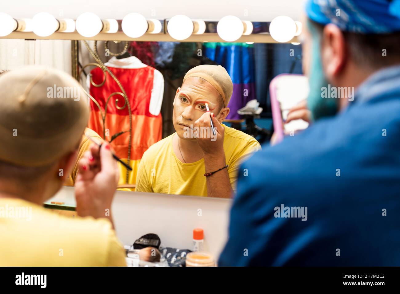 Männer, die Drag Queen im Ankleidezimmer schminken Stockfoto