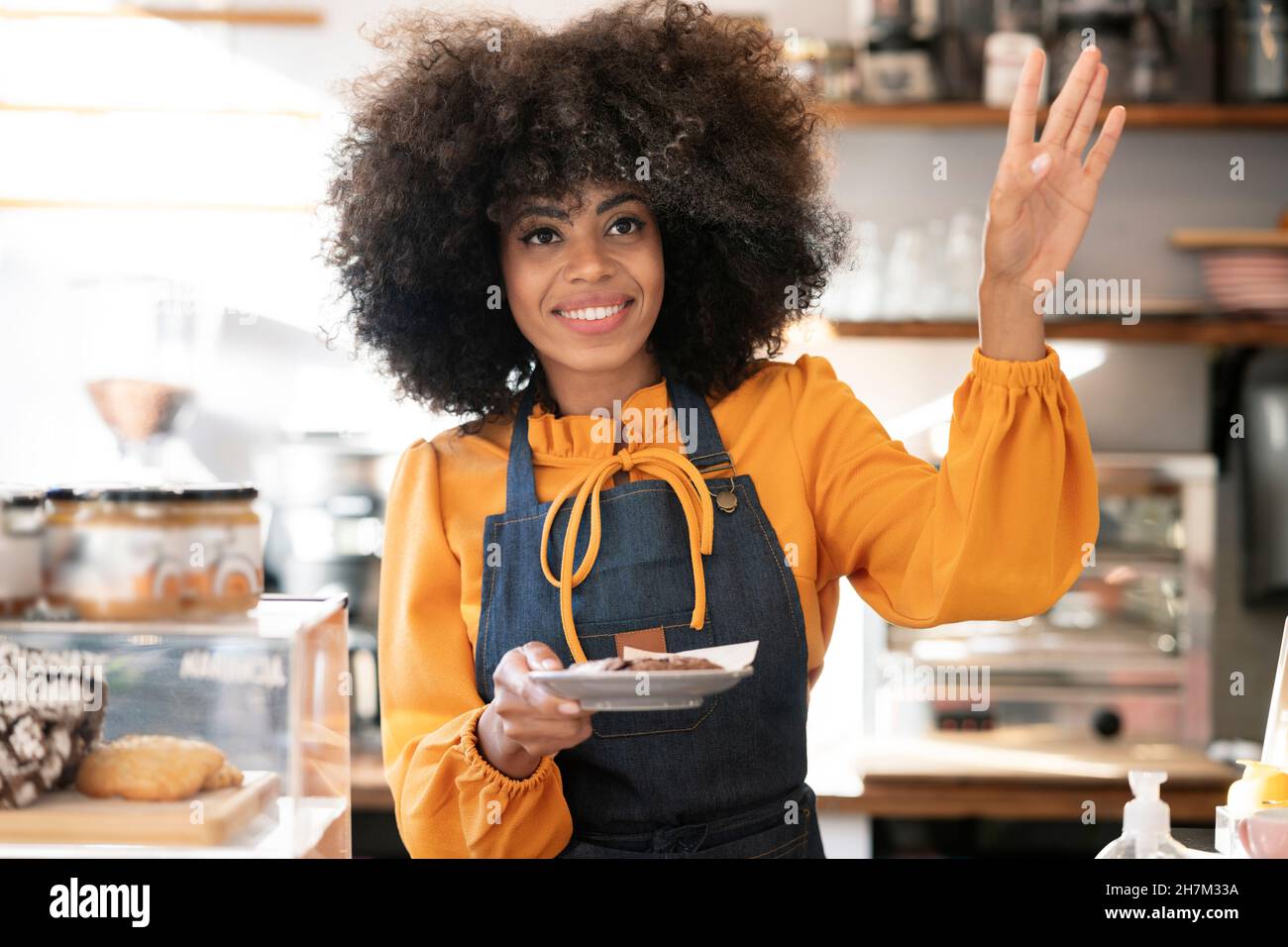 Kellnerin mit Afro-Frisur steht am Cafe-Schalter Stockfotografie - Alamy