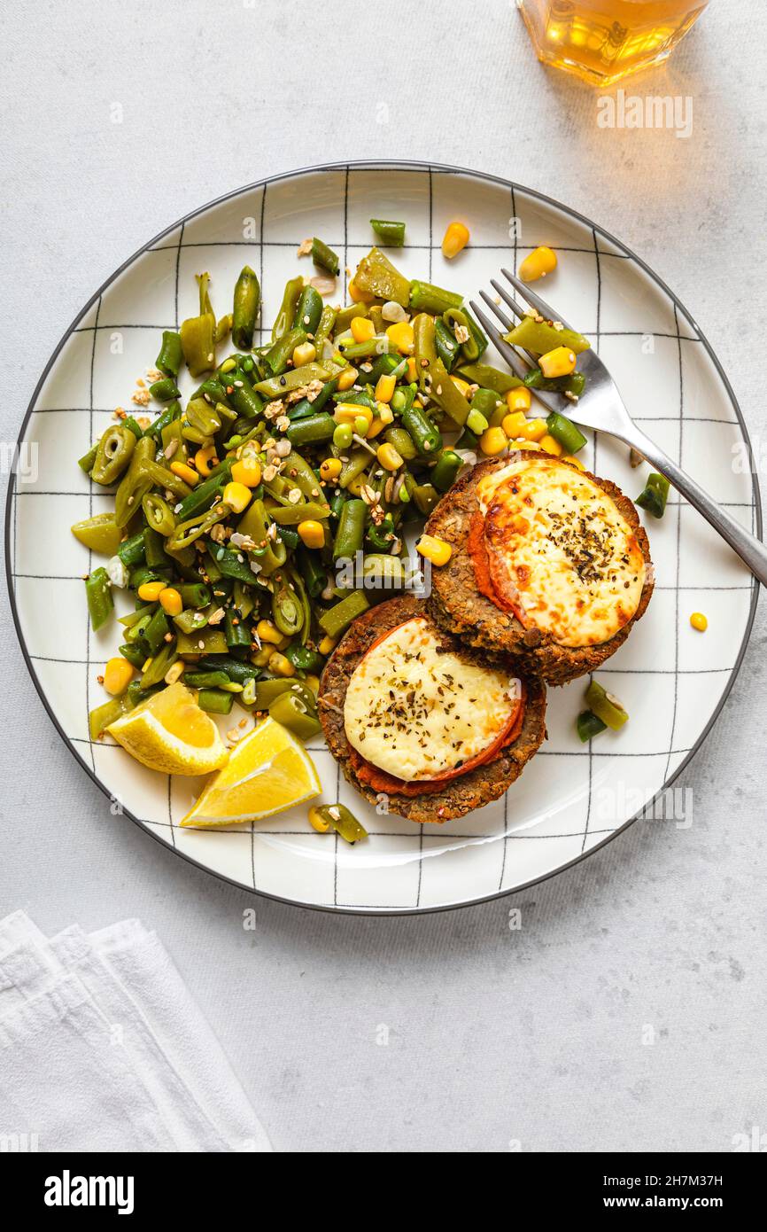 Gabel und Messer für Teller Burger mit Salat auf dem Tisch Stockfoto