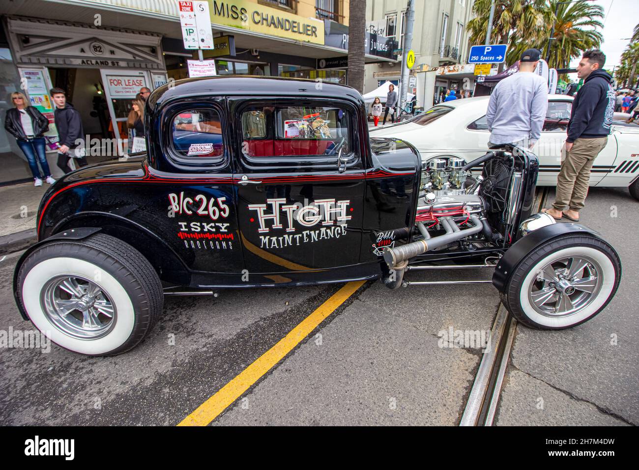 Klassisches, antikes und gut erhaltenes, in Schwarz und Rot geparktes Auto, das in den Straßen geparkt ist. Motor freigelegt. Stockfoto