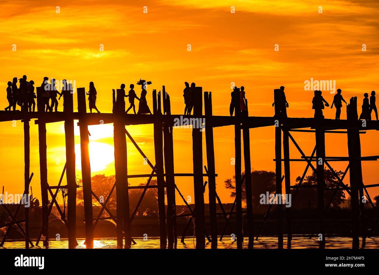 Sonnenuntergang hinter der U Bein Bridge, der längsten Teakholzbrücke der Welt in Myanmar Stockfoto