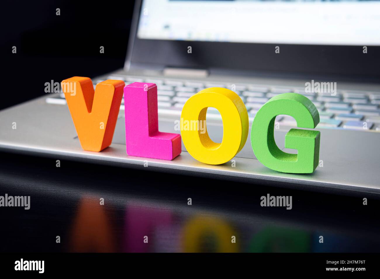 Word-Vlog auf einer schwarzen Tabelle auf dem Hintergrund des Computers. Persönliches Video-Blog-Konzept im Internet. Stockfoto