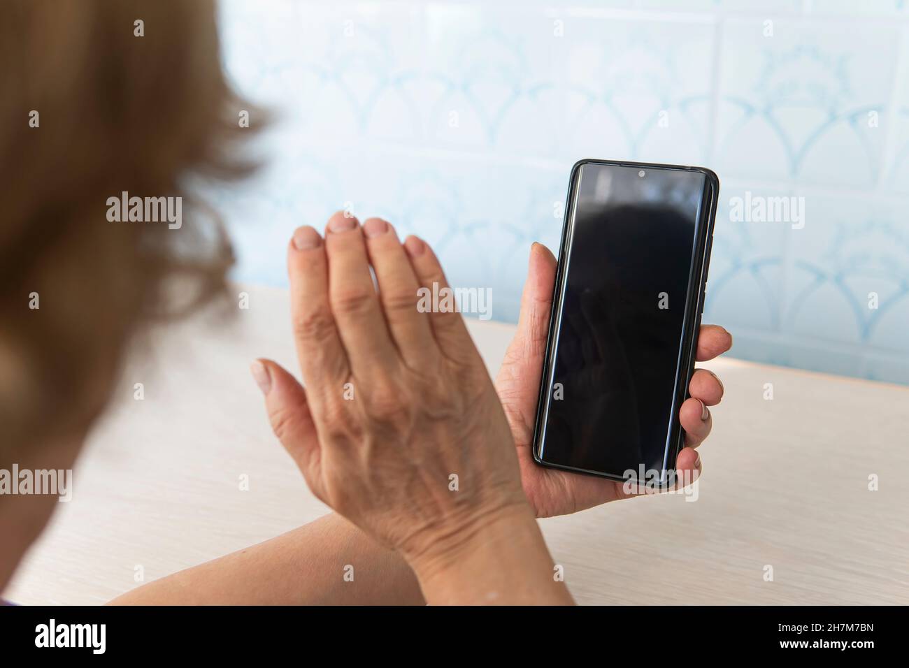 Alte Frau mit Brille hält ein Smartphone. Oma ist am Telefon. Ein älterer Mann sieht auf einen leeren Telefonbildschirm. Ein leerer Bildschirm für den Test und d Stockfoto
