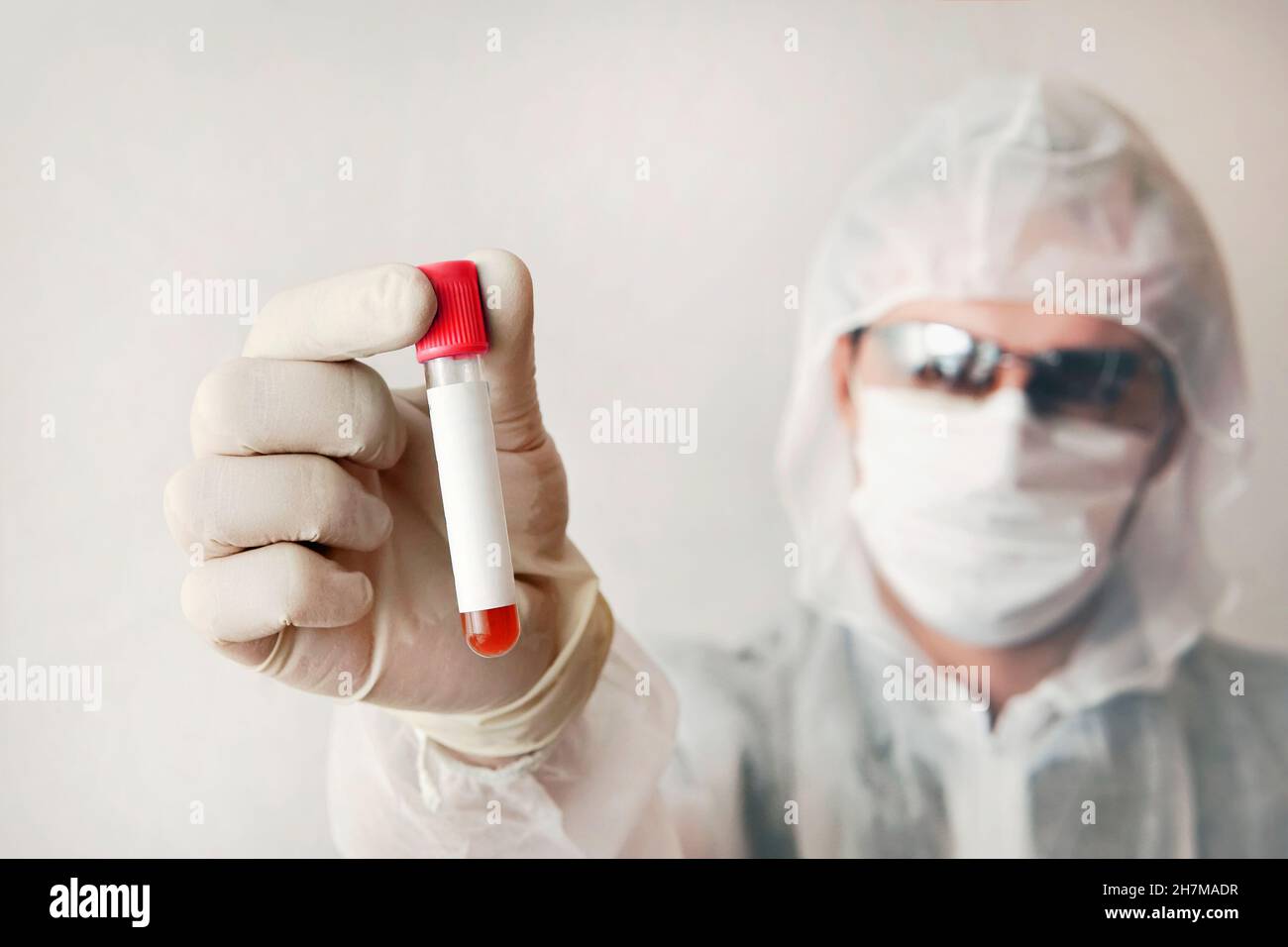 Wissenschaftler untersucht Blut auf Viren. Mann zeigt Reagenzglas. Leeres Etikett auf dem Reagenzglas. Männlicher Arzt, Techniker, der rotes Blut im Reagenzglas für die Probe hält. H Stockfoto