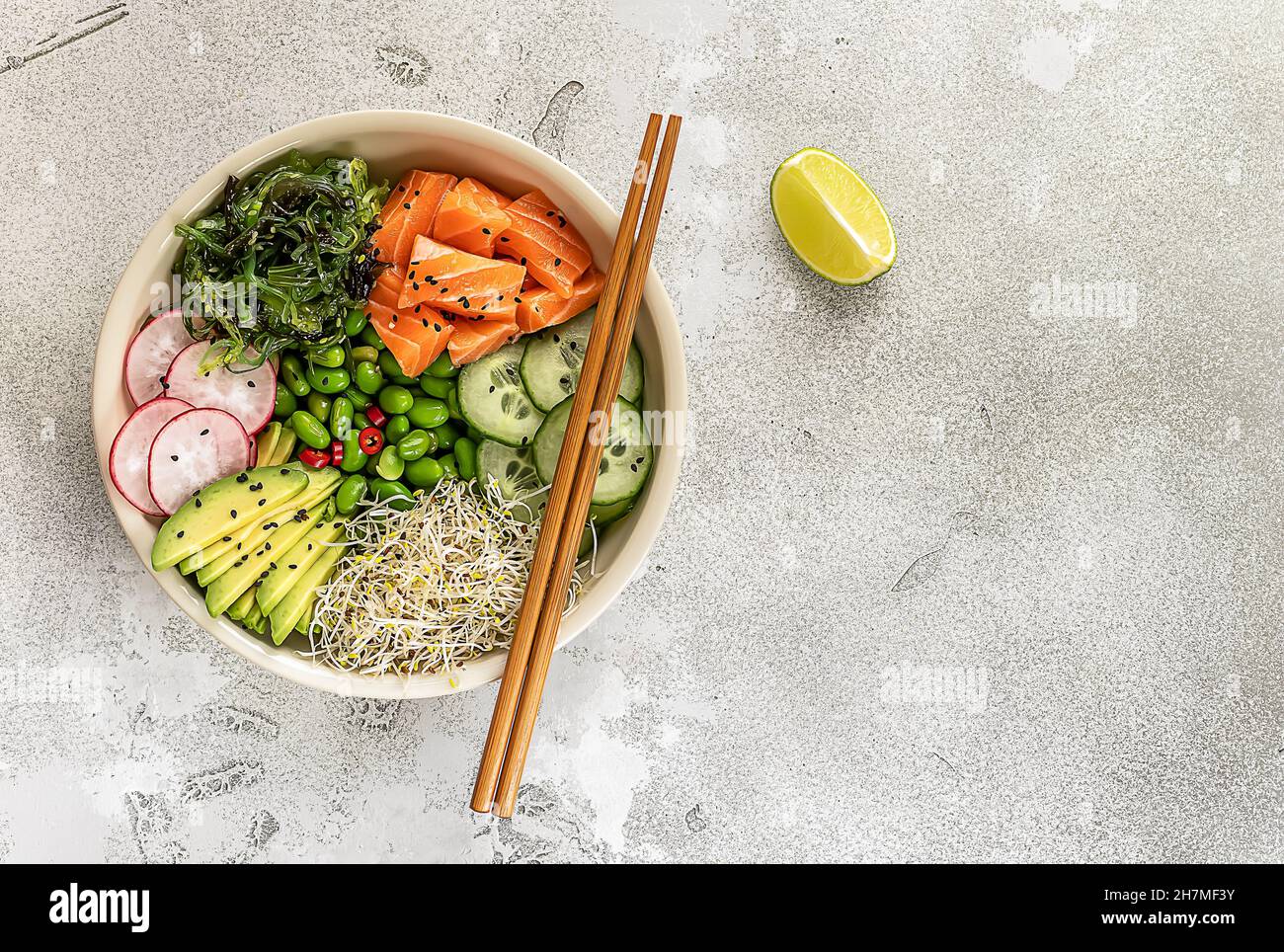 Gesunde Schüssel mit Lachs, Avocado, Edamamabohnen, Gurken, Rettich, Und Algen, Blick von oben. Stockfoto