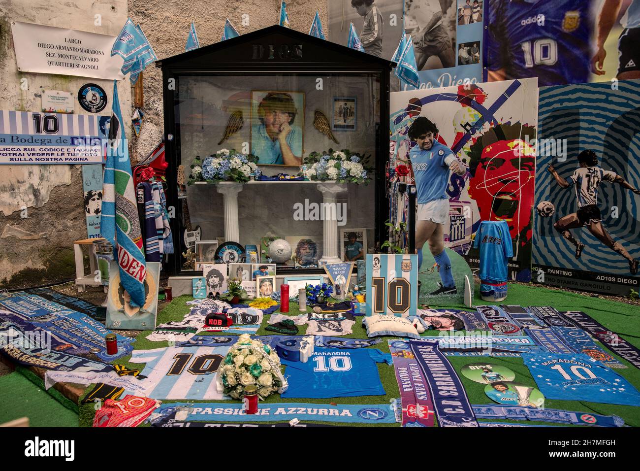 Neapel, Italien. 23rd. November 2021. Ein Altar aus Blumen, Bildern, Trikots und Kerzen zu Ehren der Fußballlegende Maradona ist in spanischen Vierteln zu sehen. Ein Jahr nach dem Tod des Fußballstars in einer Privatresidenz nördlich von Buenos Aires wird Maradona mit Tributen, Fernsehserien und Gedenkstätten gedenkt - auch in Neapel, wo der „goldene Junge“ jahrelang im SSC Neapel spielte. (To dpa 'Ein Jahr ohne Diego: Tribute und Anschuldigungen zum Todestag von Maradona') Quelle: Alessio Paduano/dpa/Alamy Live News Stockfoto