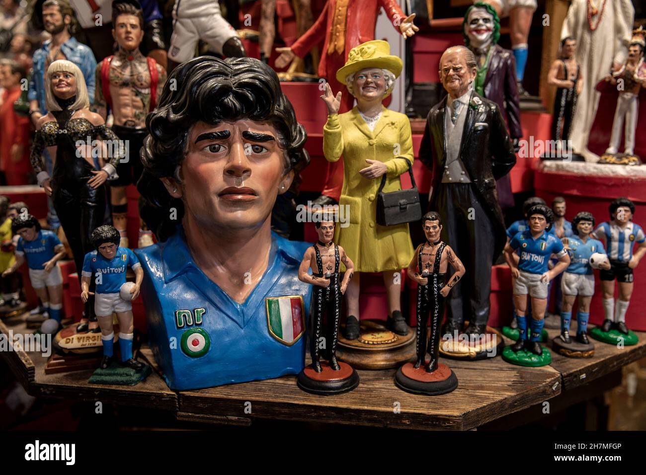 Neapel, Italien. 23rd. November 2021. Kleine und größere Figuren der Fußballlegende Maradona werden in einem Souvenirladen im Spanischen Viertel verkauft. Ein Jahr nach dem Tod des Fußballstars in einer Privatresidenz nördlich von Buenos Aires wird Maradona mit Tributen, Fernsehserien und Denkmälern gedenkt - auch in Neapel, wo der „goldene Junge“ jahrelang im SSC Neapel spielte. (To dpa 'Ein Jahr ohne Diego: Tribute und Anschuldigungen zum Todestag von Maradona') Quelle: Alessio Paduano/dpa/Alamy Live News Stockfoto