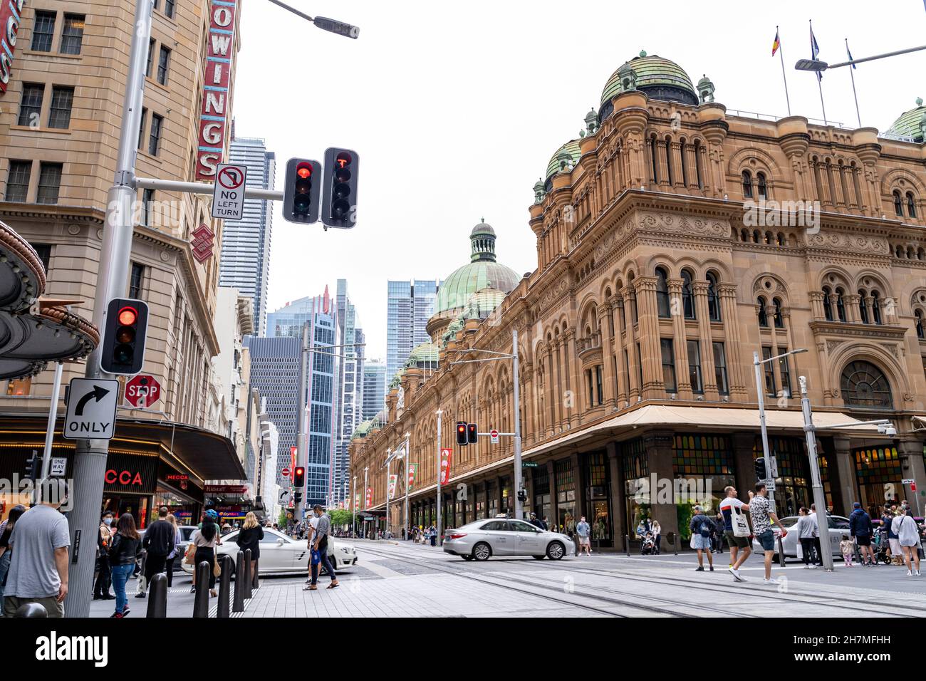 Blick auf die Straße von Menschenmassen, die Stadtbahnen überqueren, im zentralen Geschäftsviertel in der Nähe des Queen Victoria-Gebäudes Sydney, Australien, 20. November 2021. Stockfoto