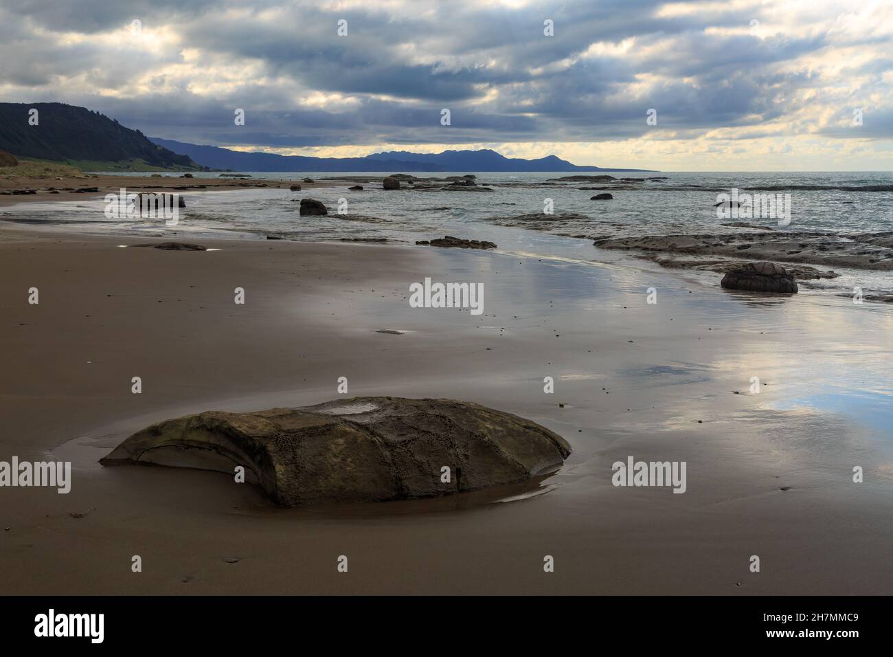 Hautai Beach am East Cape, dem östlichsten Teil der neuseeländischen Landschaft. Von den Hügeln weht Sturmwolken ein Stockfoto