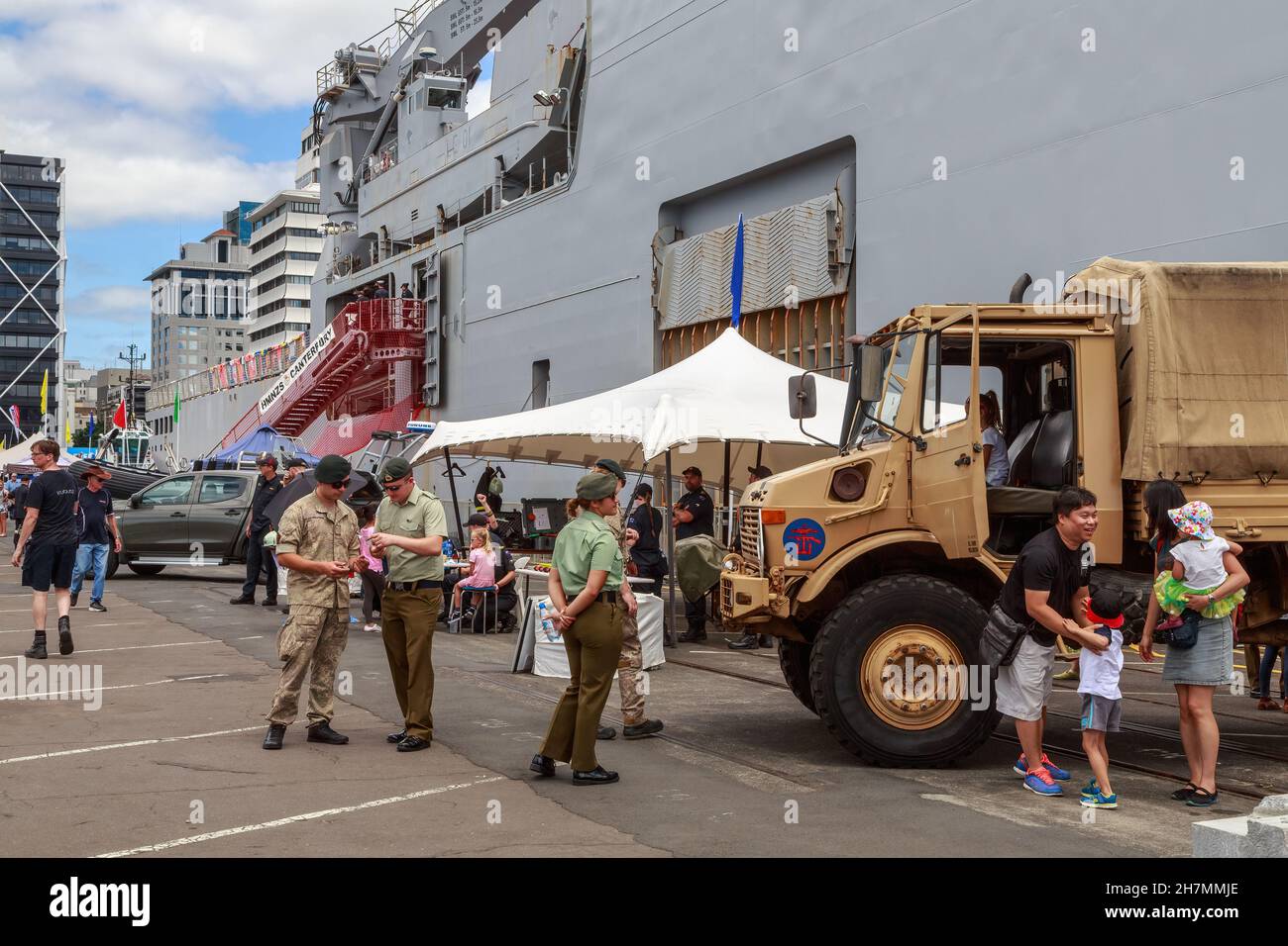 Mitglieder der neuseeländischen Streitkräfte und ein Unimog-LKW im Hafen von Auckland, Neuseeland. Im Hintergrund ist das Schiff HMNZs Canterbury zu sehen Stockfoto