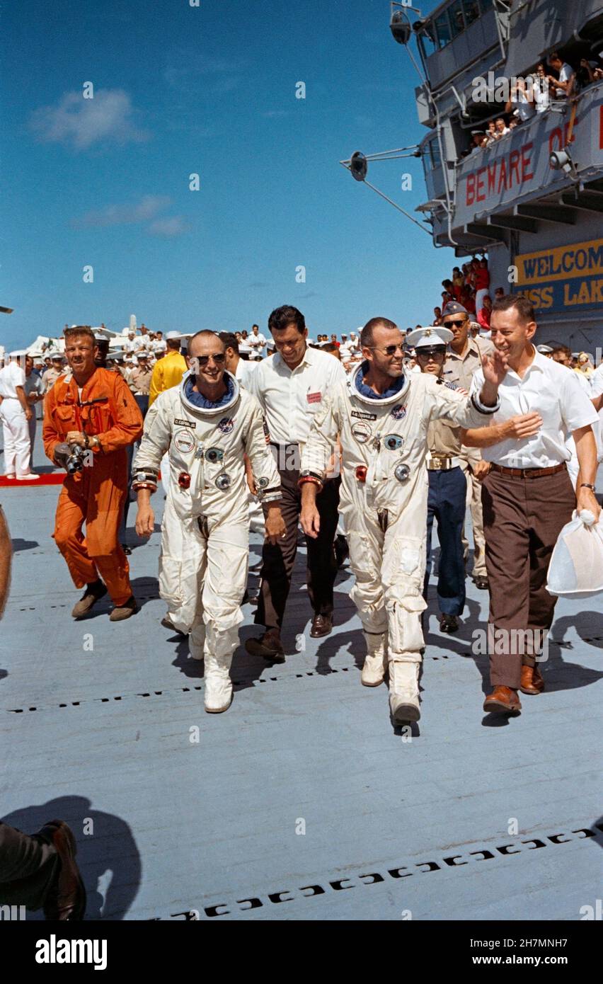 (29. August 1965) --- die Astronauten L. Gordon Cooper Jr. (rechts) und Charles Conrad Jr., Gemini-Titan 5 Crew, überqueren nach der Erholung vom Meer das Deck des Flugzeugträgers USS Lake Champlain Stockfoto