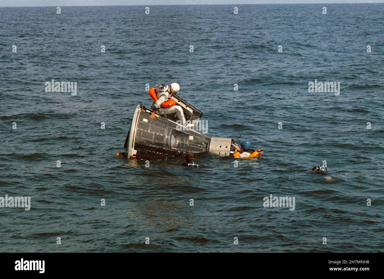 (15. Oktober 1965) --- der Astronaut James A. Lovell Jr., Pilot der Hauptmannschaft für die Raumfahrt Gemini-7, sitzt auf dem statischen Testartikel der Gemini-Raumsonde während des Wasseraustrainings im Golf von Mexiko. Astronaut Frank Borman (mit blauem Helm), Kommandopilot der Hauptmannschaft, hängt an der Nase des Raumschiffs. NASA-Taucher sind aus Sicherheitsgründen im Wasser Stockfoto