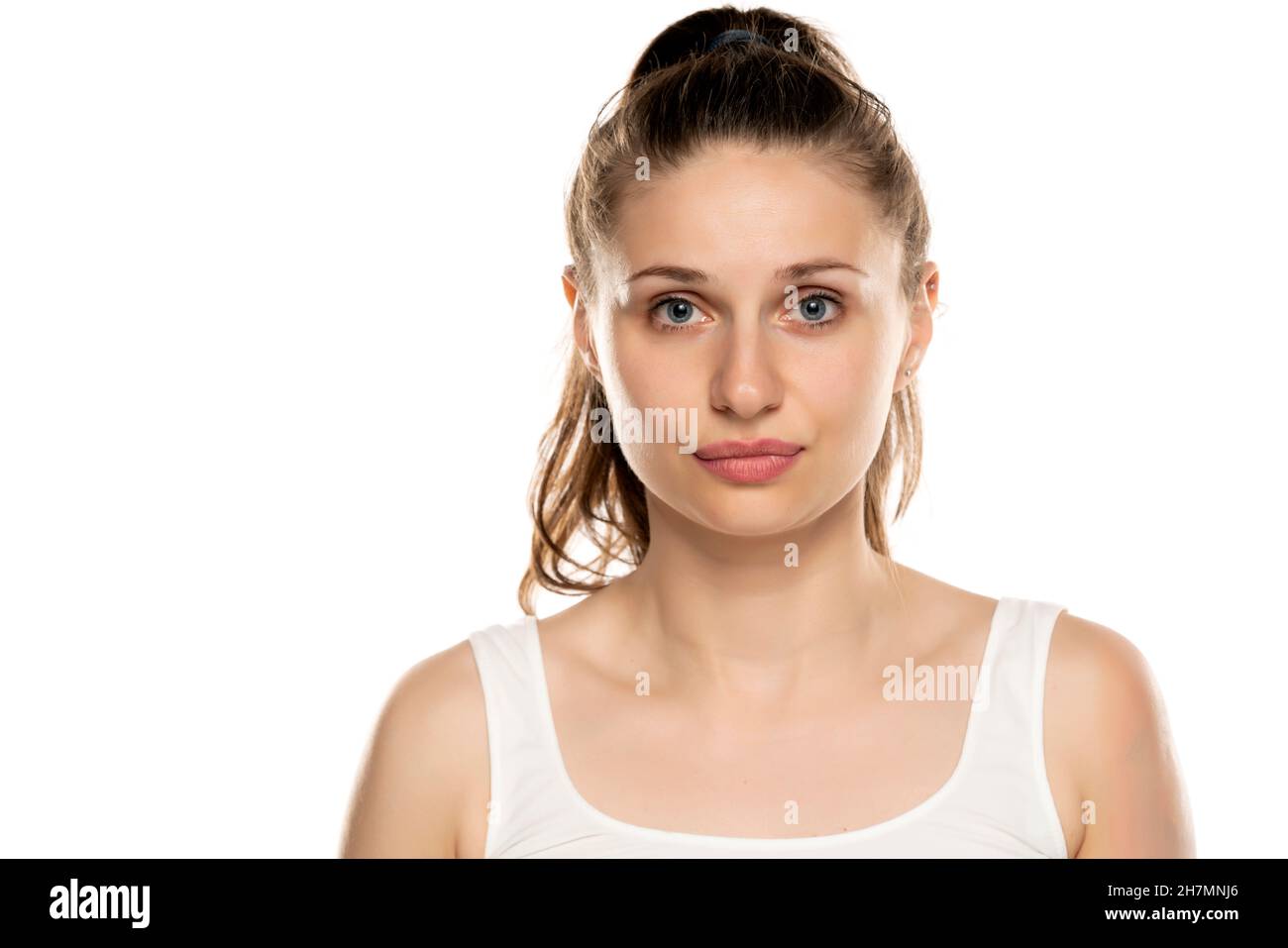 Porträt einer ernsthaften Frau mit blauen Augen und ohne Make-up auf weißem Hintergrund Stockfoto