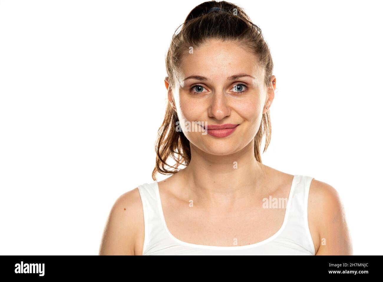 Porträt einer lächelnden Frau mit blauen Augen und ohne Make-up auf weißem Hintergrund Stockfoto