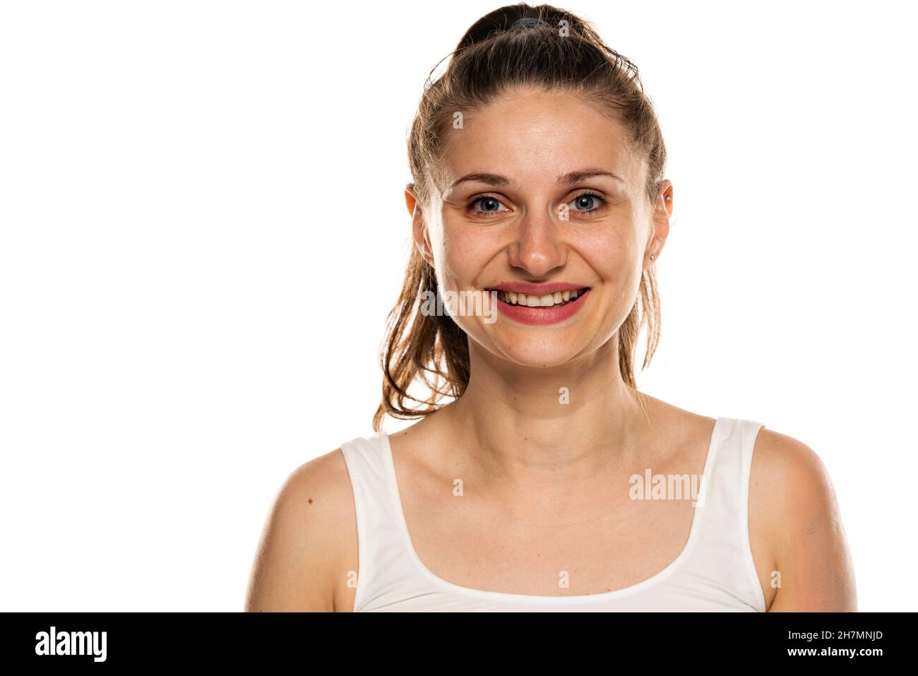 Porträt einer lächelnden Frau mit blauen Augen und ohne Make-up auf weißem Hintergrund Stockfoto
