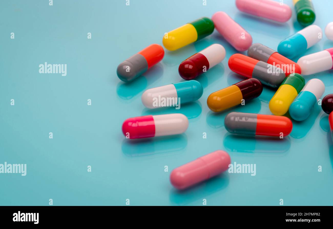 Antibiotische Kapsel Pillen auf blauem Hintergrund. Verschreibungspflichtige Medikamente. Bunte Kapsel Pillen. Antibiotikaresistenzkonzept. Pharmaindustrie. Stockfoto