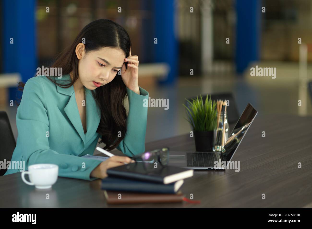 Gestresste, professionelle Managerin, die im Büro an ihrem Projekt arbeitet. Nachdenkliche, nachdenkliche, nachdenkliche Person. Stockfoto