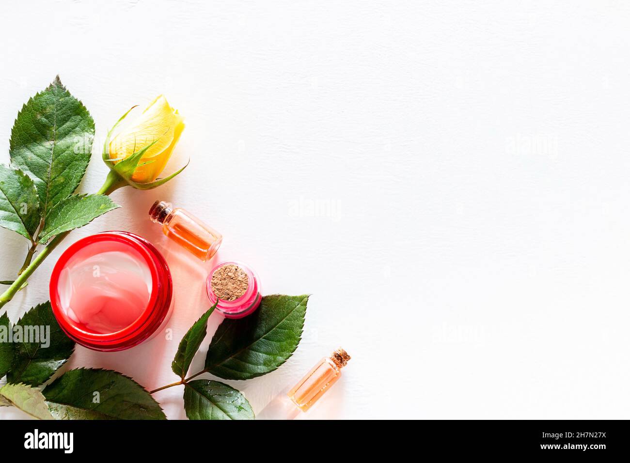 Blumen und Naturkosmetik auf weißem Hintergrund mit Platz für Text Stockfoto