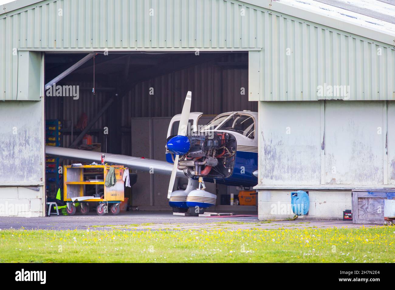 Kleiner Flächendecker in einem offenen Hangar mit ausgeschaltetem Motorhaube. Stockfoto