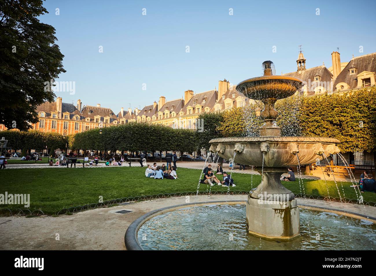 Abendstimmung mit Brunnen vor mittelalterlichen Fassaden. Blick auf das Zentrum von Place des Vosges, Marais, 3rd und 4th Arrondissement, Paris Stockfoto