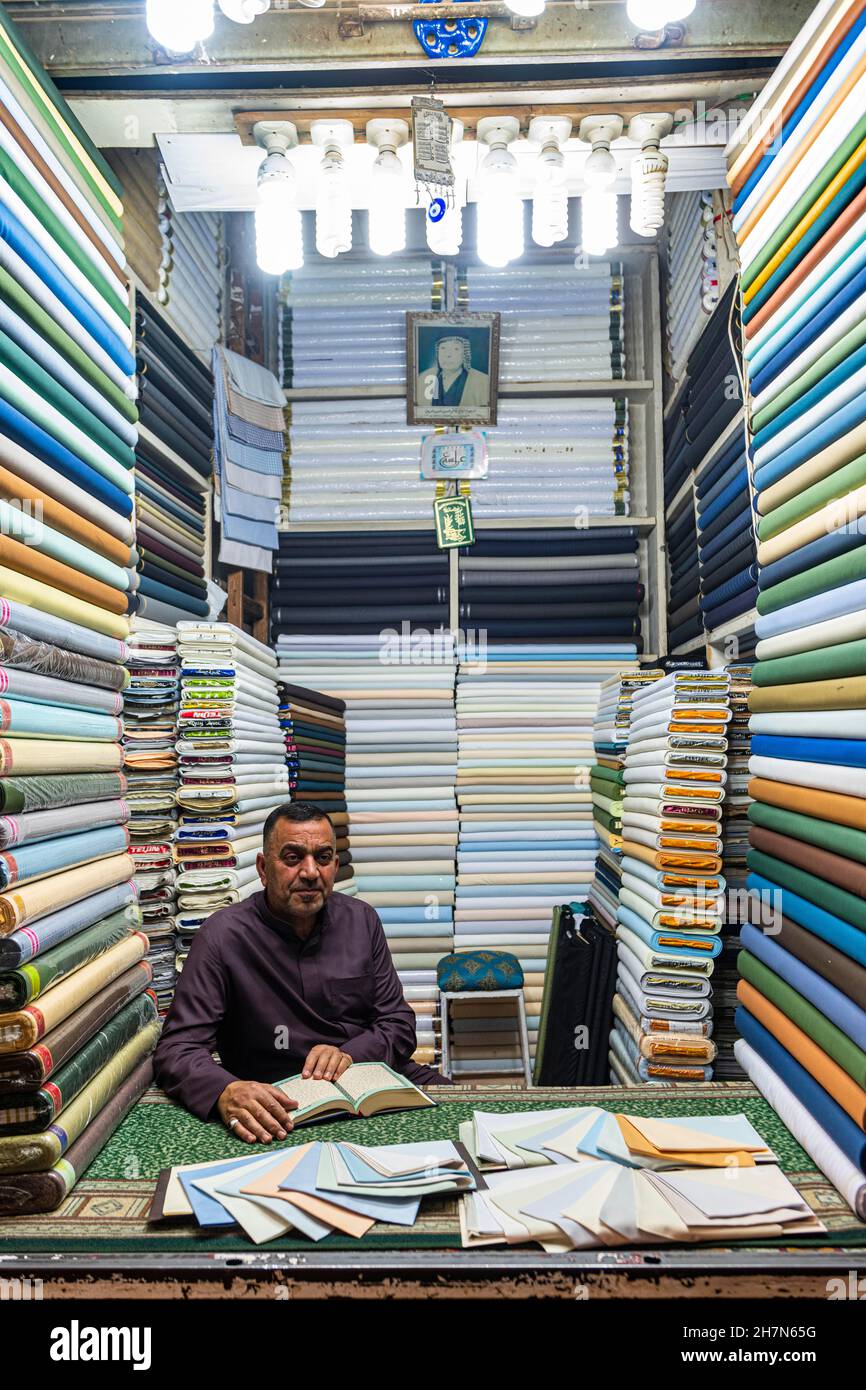 Mann in seinem Tuchladen im Imam Ali Holy Shrine, Najaf, Irak Stockfoto