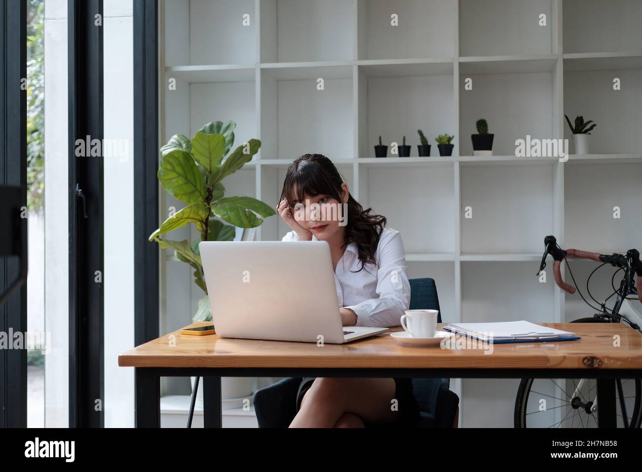 Gelangweilte junge asiatische Frau müde von Laptop-Computer-Arbeit oder Online-Studie zu Hause Stockfoto