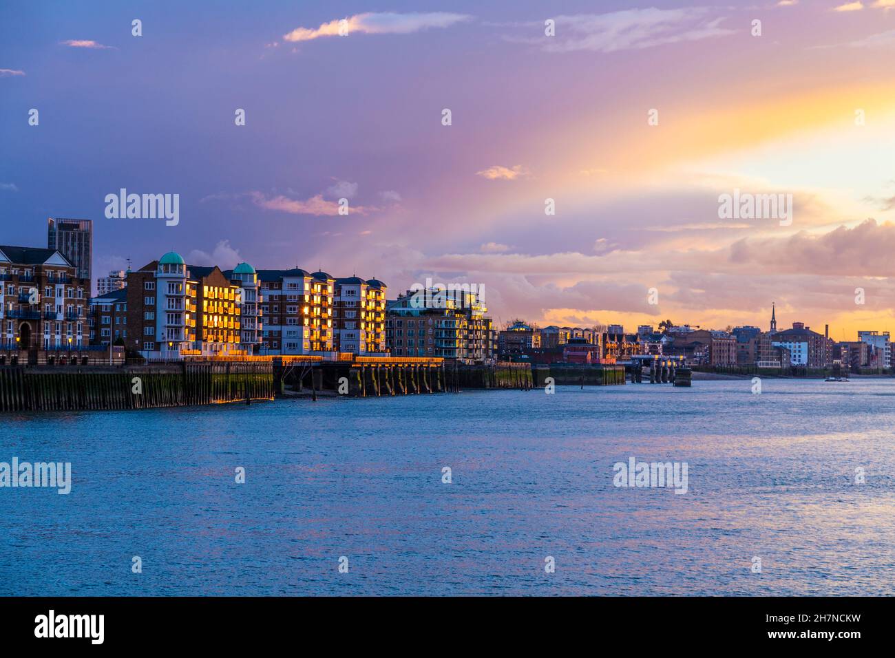 Wohngebäude in Rotherhithe, beleuchtet von Sonnenuntergang und der Themse, London, Großbritannien Stockfoto