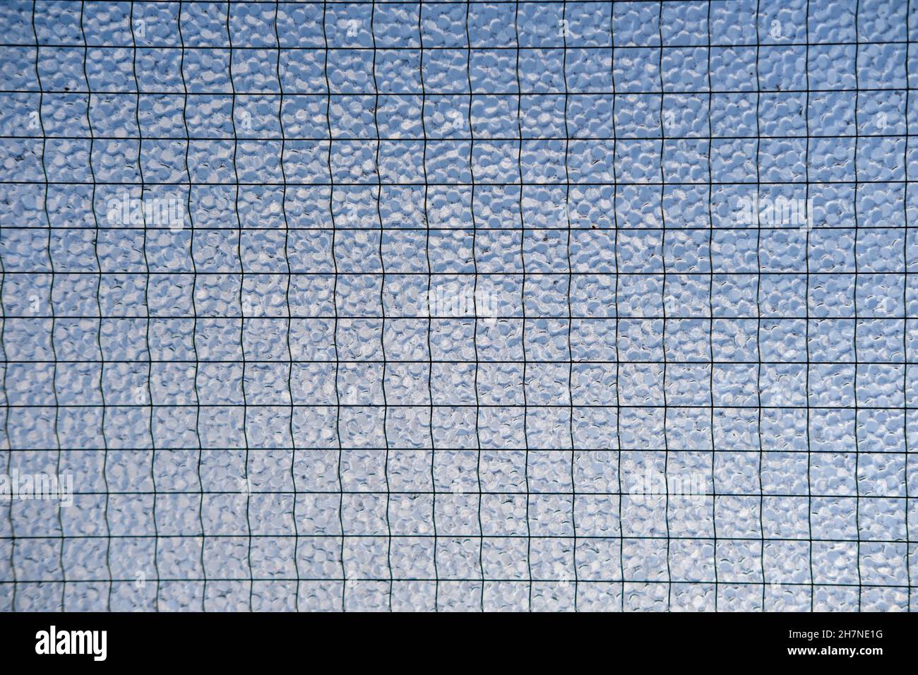 Nahaufnahme von mattiertem Sicherheitsglas vor blauem Himmel Stockfoto