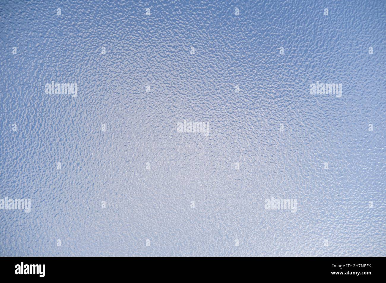 Nahaufnahme von undurchsichtigem Milchglas vor blauem Himmel Stockfoto