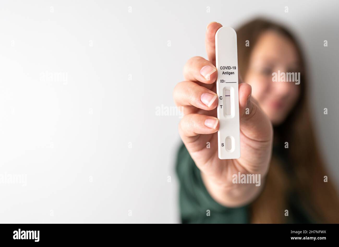Negativer Schnellantigen-COVID-19-Test in der Hand einer unkenntlich unscharfen Person mit Kopierraum. Frau zeigt ihr Testergebnis. Reisen während des Coronavirus-Pandemiekonzepts. Stockfoto