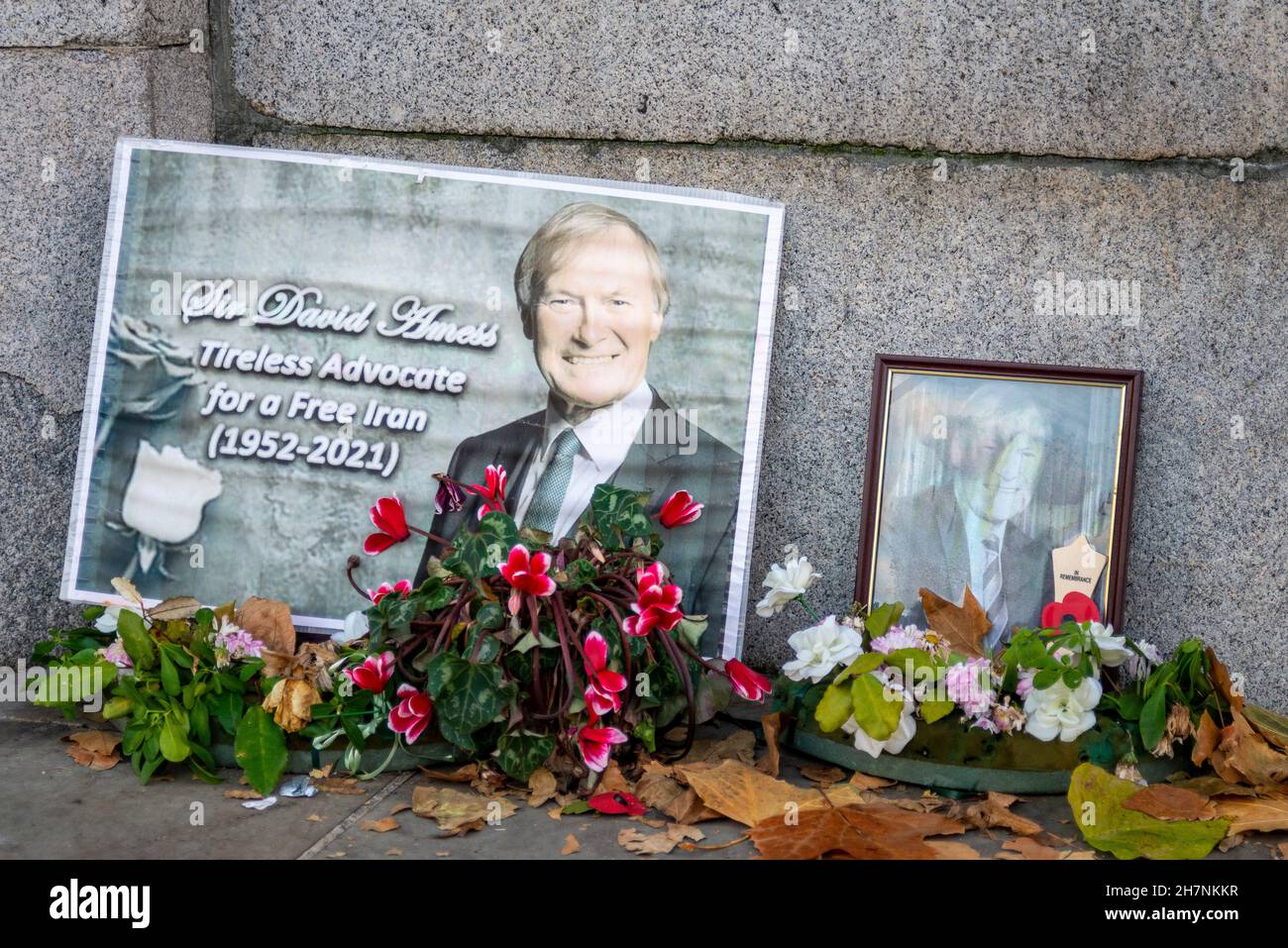 Verblasste Hommage vor dem Parlament an den ermordeten Abgeordneten Sir David Amess, mit alten blumigen Ehrungen. In der Nähe des Eingangs zum Unterhaus Stockfoto