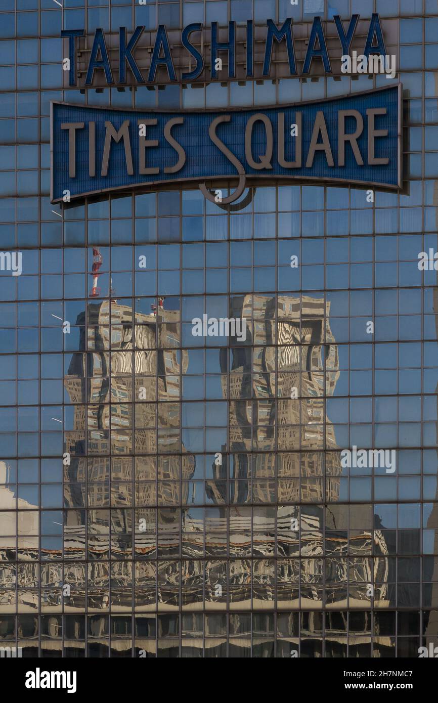 Die Zwillingstürme des Tokyo Metropolitan Government Building spiegeln sich in den Fenstern des Takashimaya Times Square Einkaufszentrums wider. Shinjuku, Tokio, Japan Stockfoto