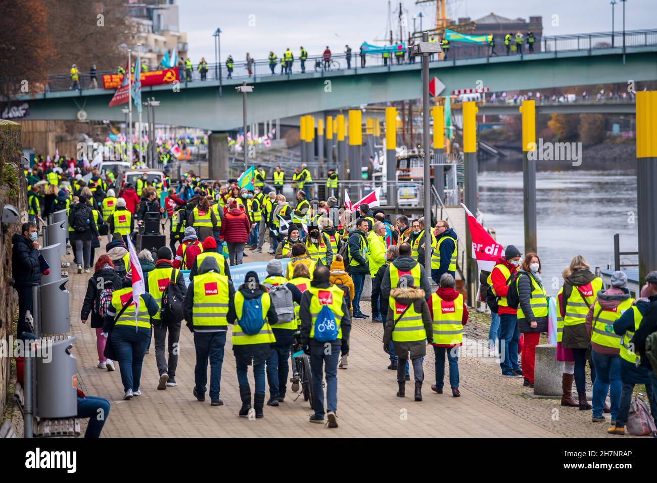 Bremen, Deutschland. 24th. November 2021. An der Weserpromenade zwischen Bürgermeister-Smidt-Brücke und Wilhelm-Kaisen-Brücke demonstrieren die Beschäftigten des öffentlichen Dienstes mit einer Menschenkette. Im anhaltenden Tarifkonflikt für die Beschäftigten der Bundesländer setzt die Gewerkschaft Verdi ihre Warnstreiks fort. Verdi und der Beamtenverband dbb fordern bundesweit fünf Prozent mehr Lohn für die mehr als eine Million Staatsangestellte, mindestens aber 150 Euro pro Monat und sogar 300 Euro mehr im Gesundheitswesen. Quelle: Sina Schuldt/dpa/Alamy Live News Stockfoto