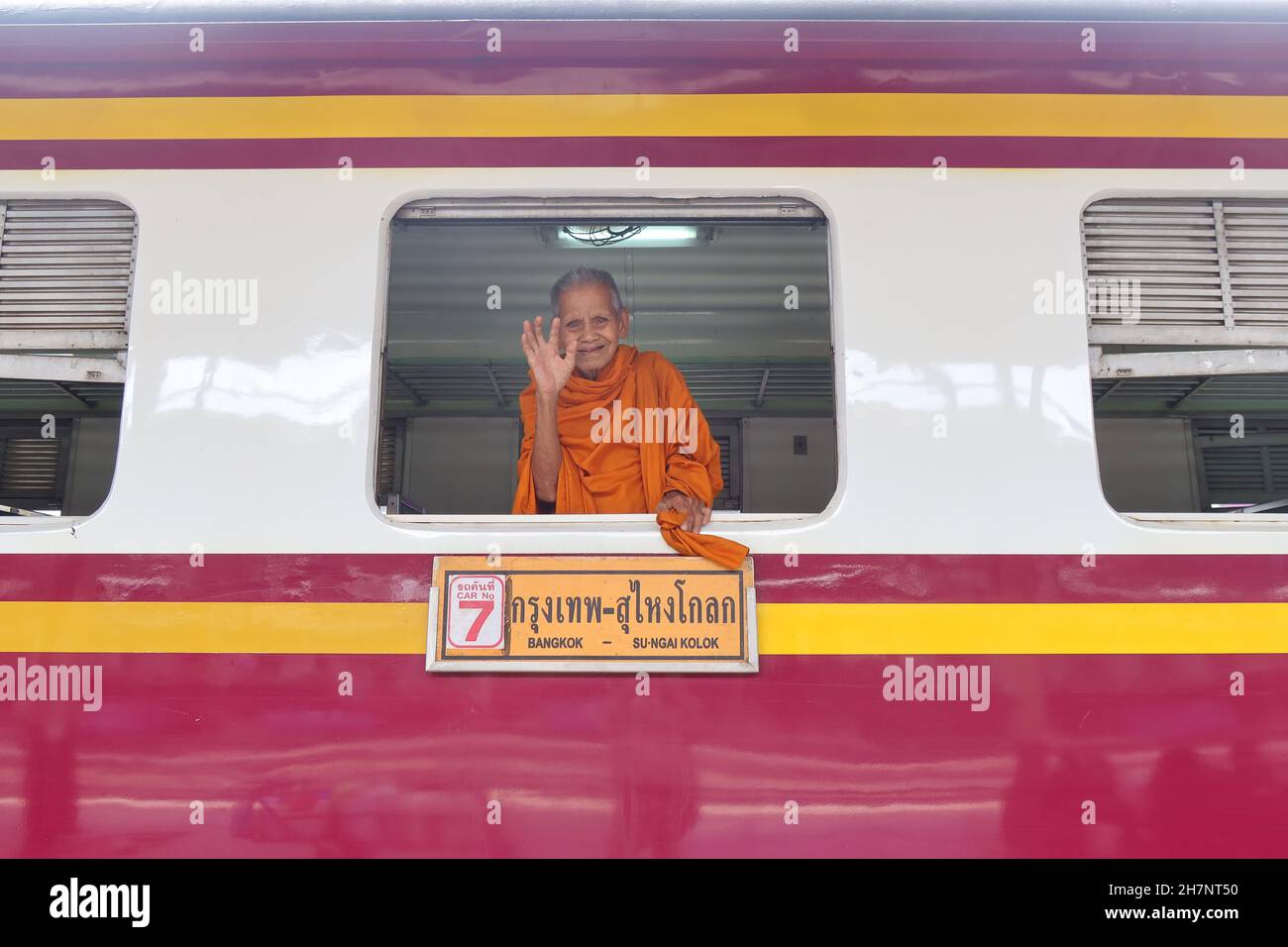 Lächelnder buddhistischer Mönch winkt vom Bahnhof in Bangkok, Thailand Stockfoto