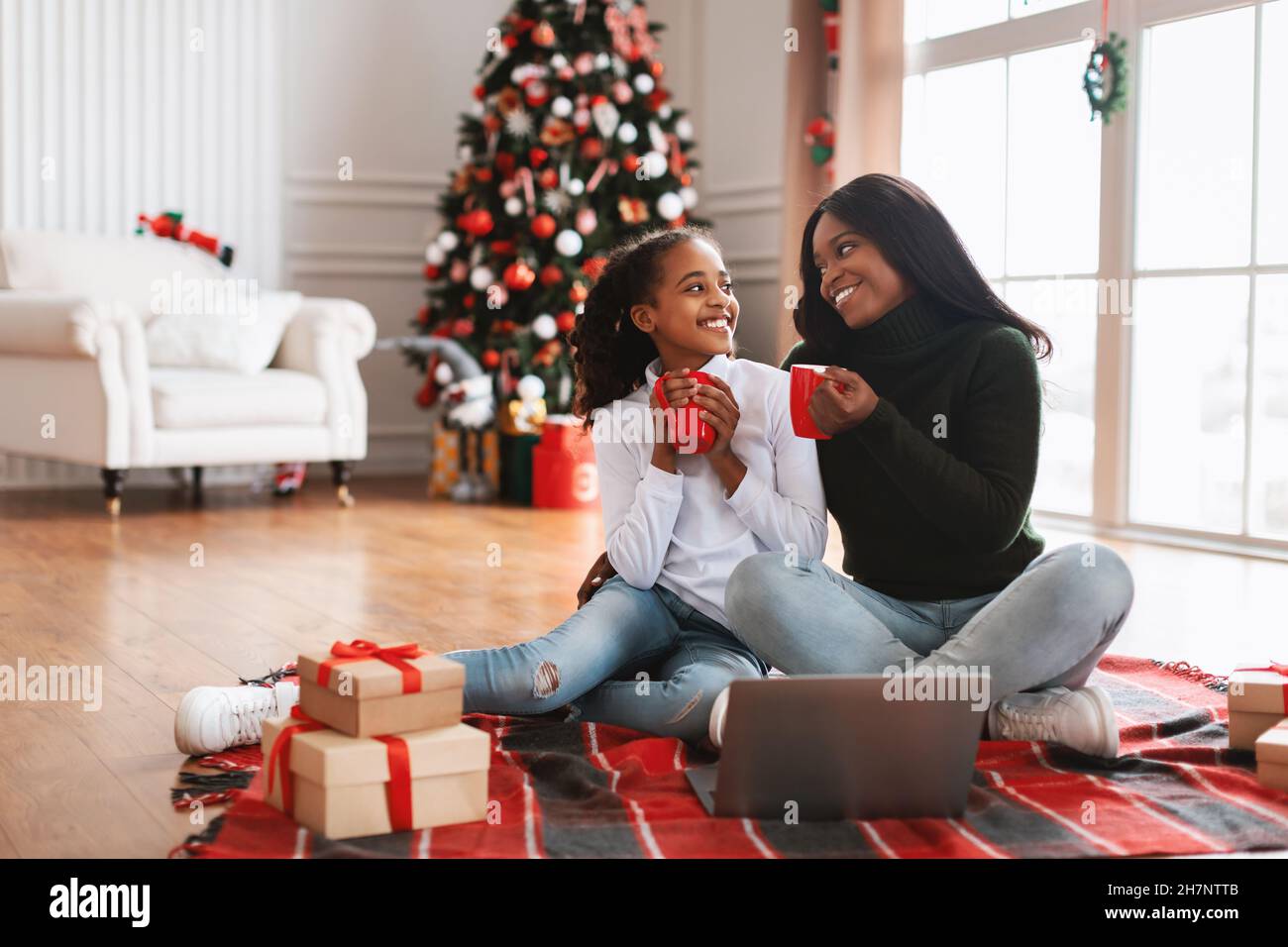 Porträt glücklicher schwarzer Frauen, die am Weihnachtsabend Kaffee trinken Stockfoto