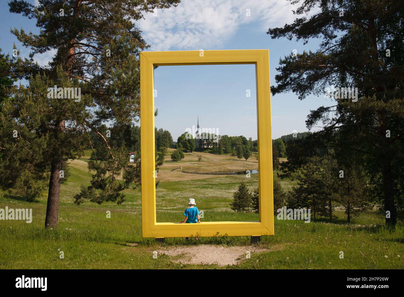 Blick durch das gelbe Fenster von National Geographic nach Otepaa. St. Mary Lutheran Church an einem sonnigen Sommertag. Stockfoto