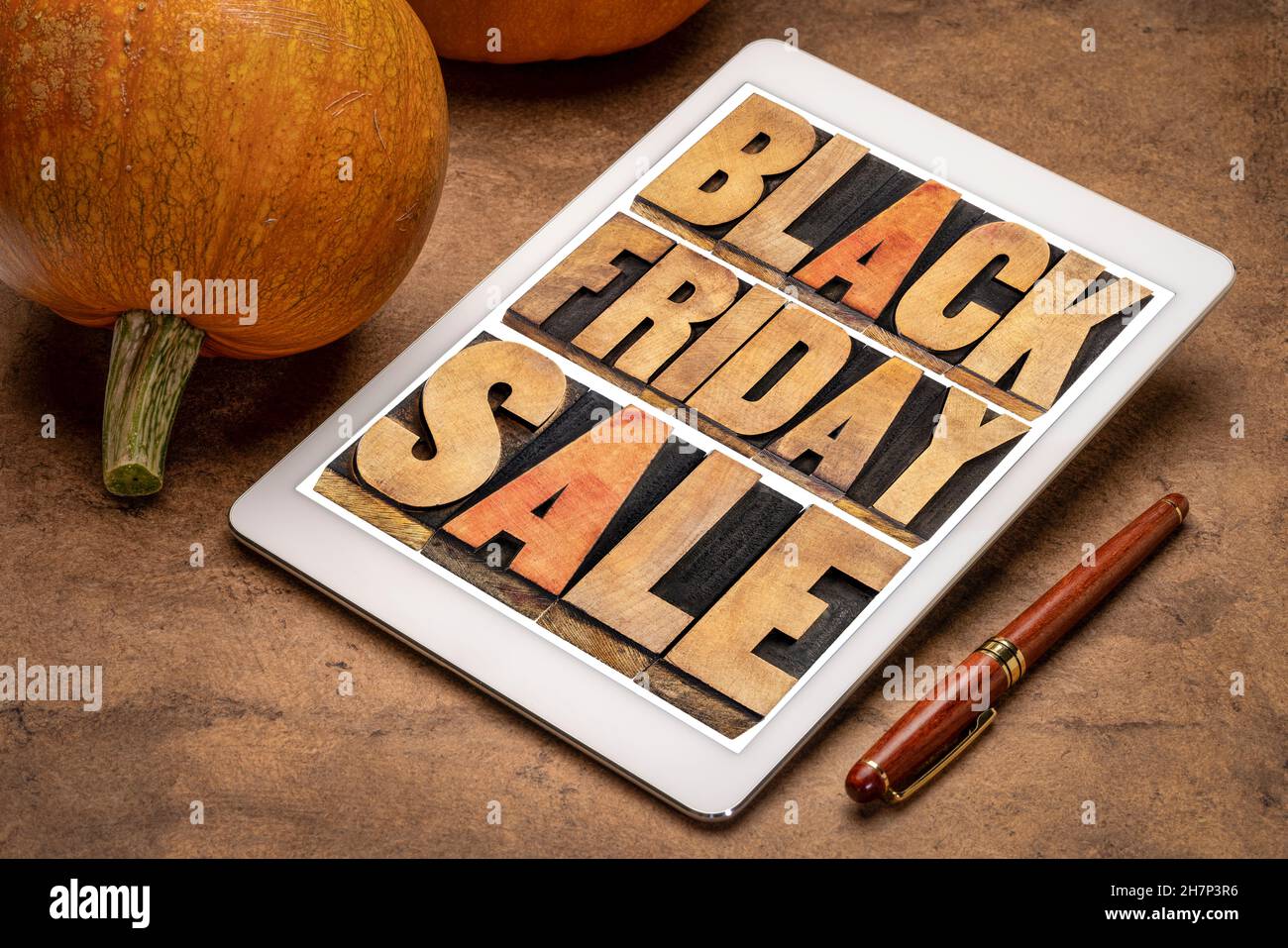 Black Friday Sale - Holiday Shopping Concept - Wortabstrakt im Buchdruck Holzart auf einem digitalen Tablet mit Kürbissen Stockfoto