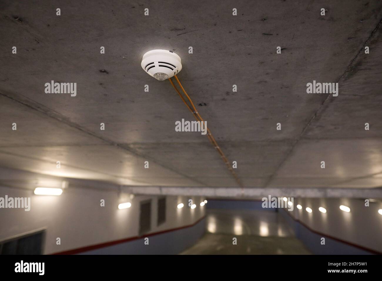 Bild mit geringer Schärfentiefe (selektiver Fokus) mit einem Rauchmeldersensor in einer Tiefgarage. Stockfoto