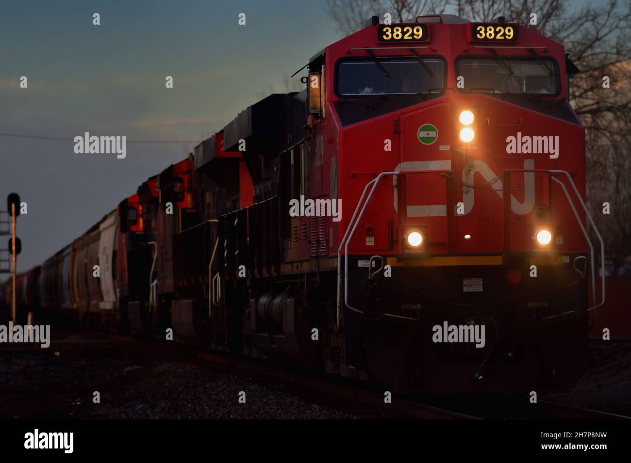 Elgin, Illinois, USA. Eine Canadian National Railway Lokomotiven führen einen Güterzug, während sie die Gleise der Canadian Pacific Railway überqueren. Stockfoto