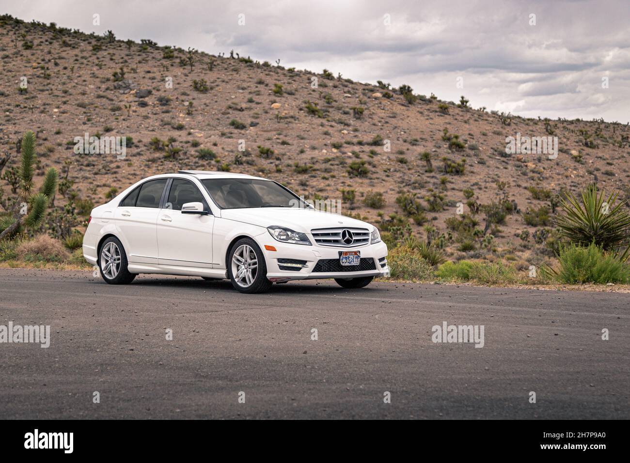 LAS VEGAS, USA - 22. Mai 2015: Vorderansicht der weißen Mercedes-Benz C-Klasse 2014, einer kleinen Luxuslimousine, in der Wüstenlandschaft von Nevada, USA. Stockfoto
