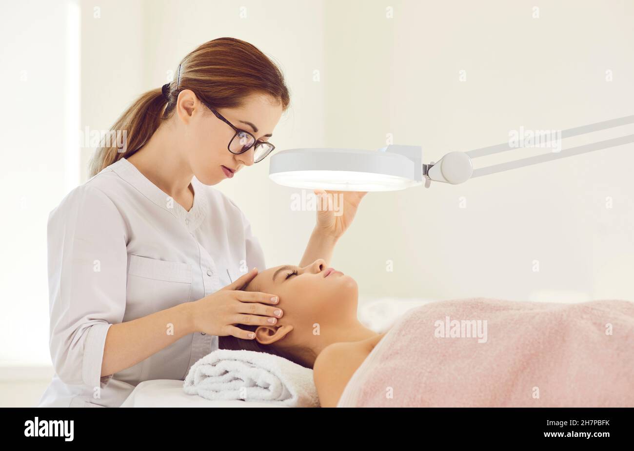 Weibliche Kosmetologin führt Hautpflegeverfahren für weibliche Klientin durch Stockfoto