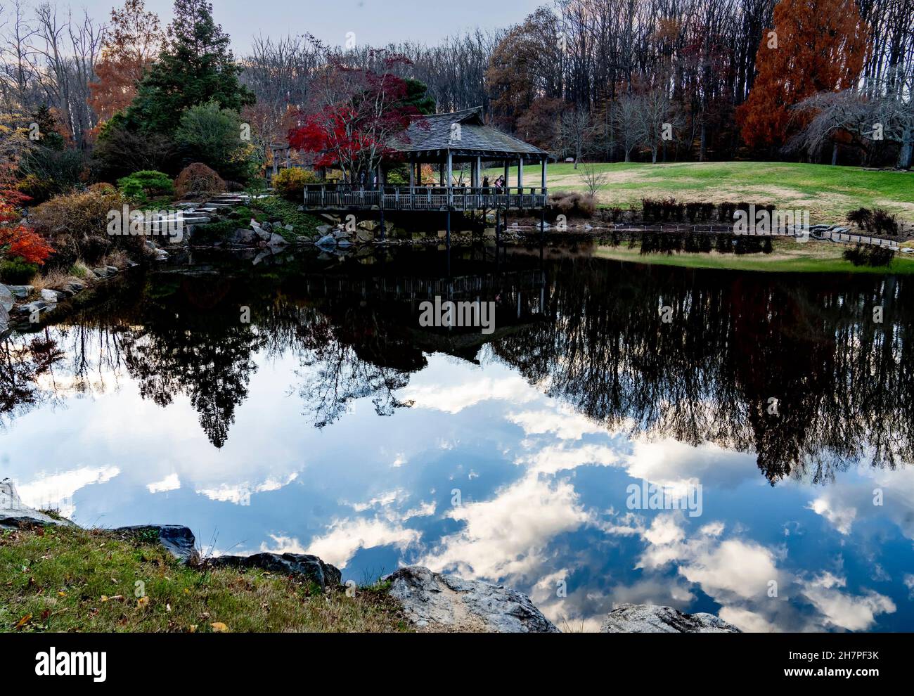 Die Wolkenbildung hallte im klaren Wasser eines Parks. Stockfoto